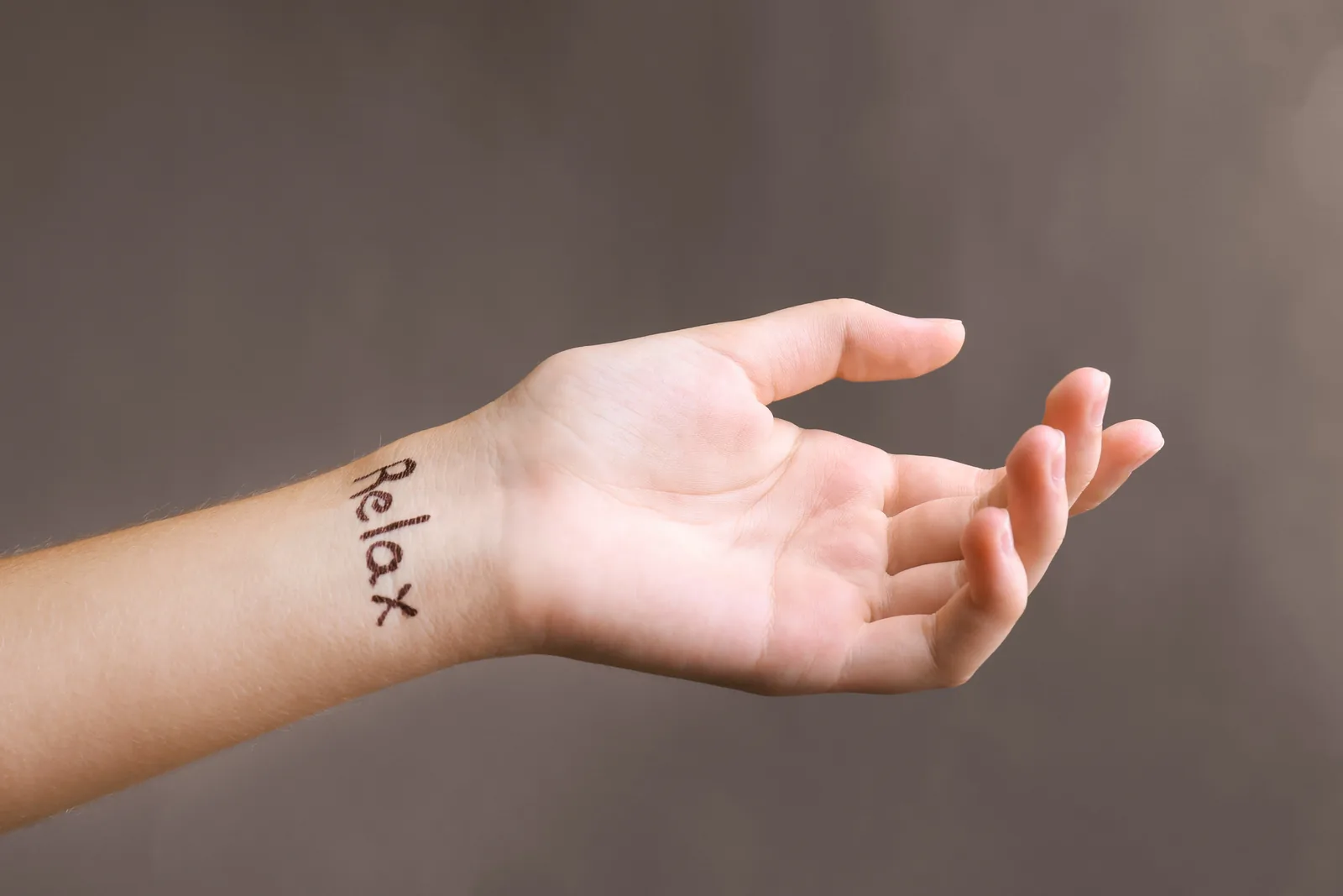 Pols met een kleine tattoo in fijne letters.