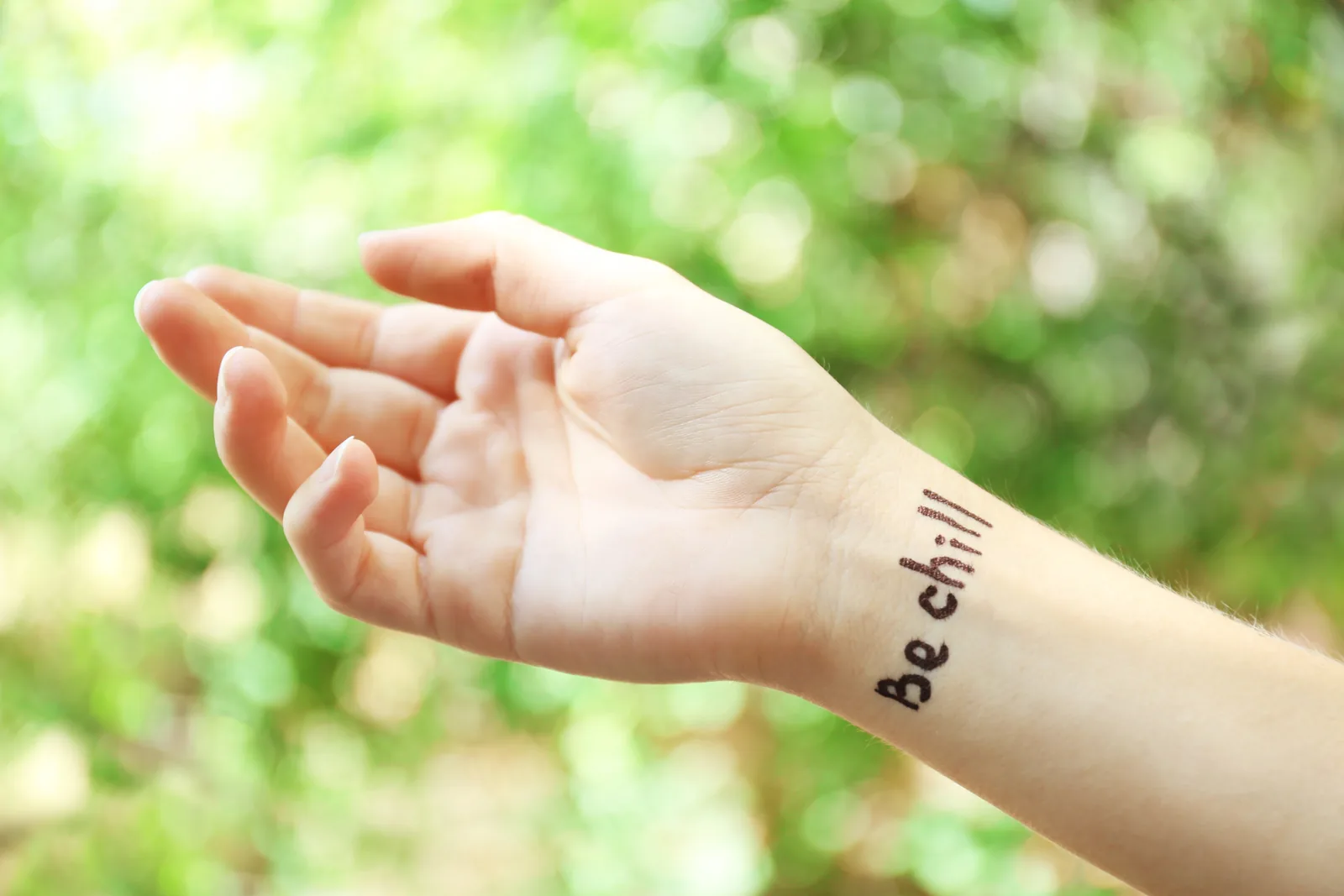 Pols met een kleine tattoo in letters.