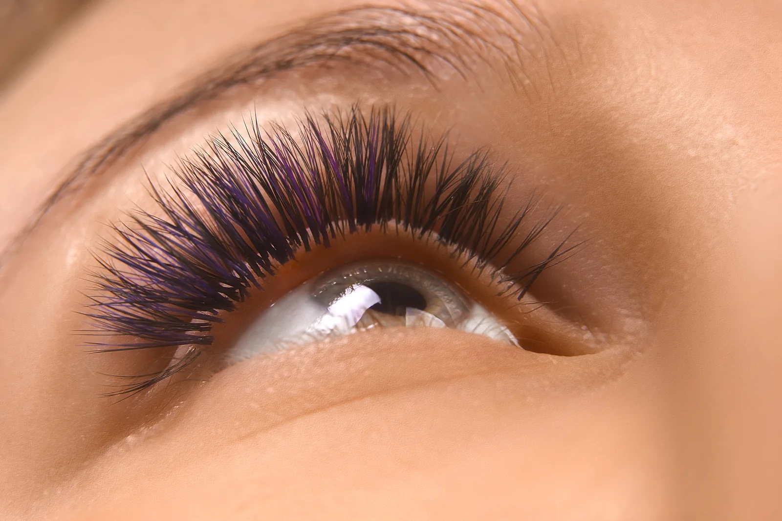 Close-up van een oog met lange, gekrulde wimpers.