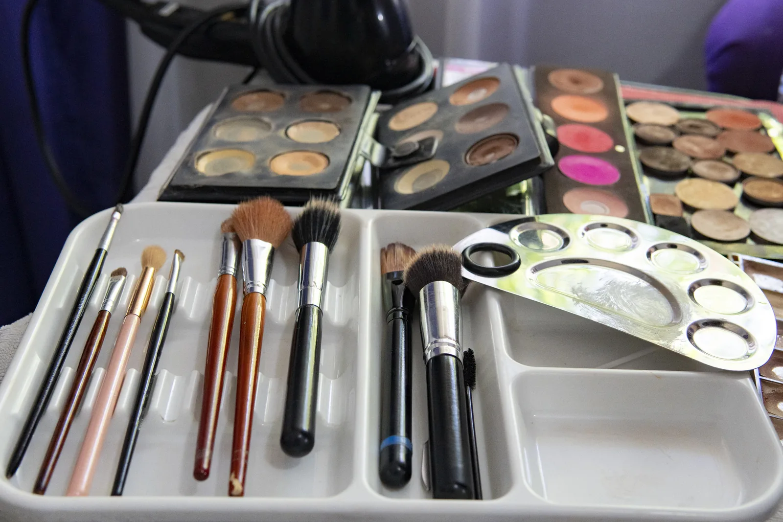 Volledige make-upkoffer van een make-up artist met penselen en paletten.