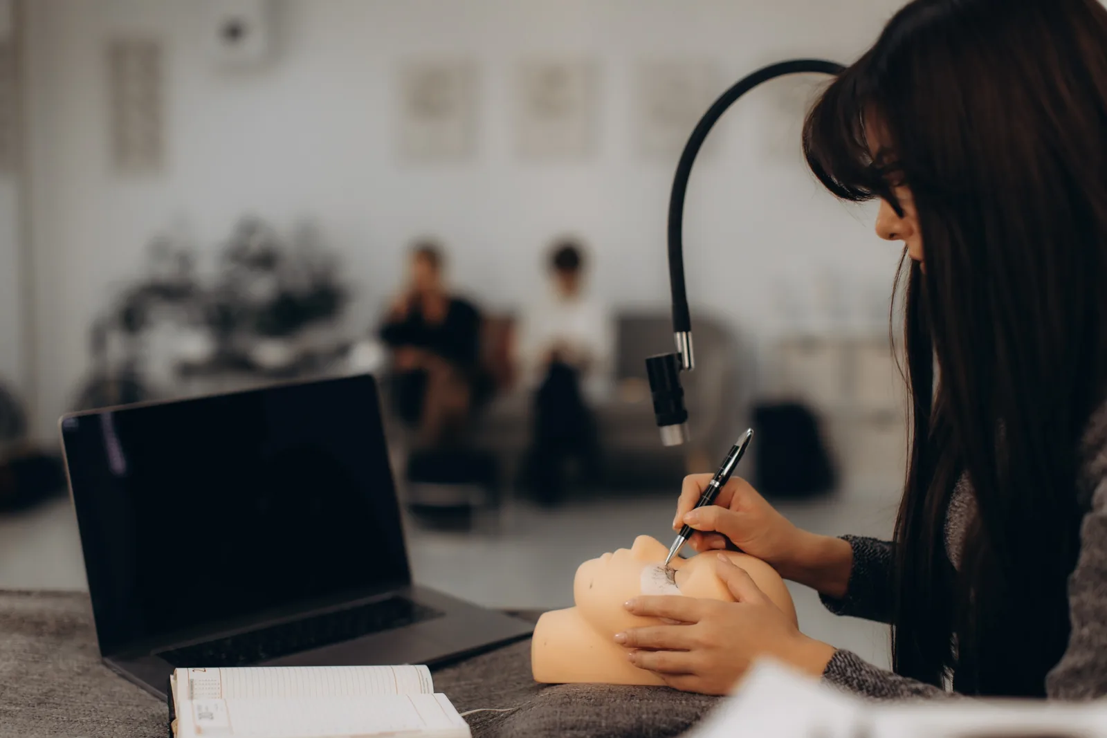 Cursist oefent make-up op een oefenhoofd.