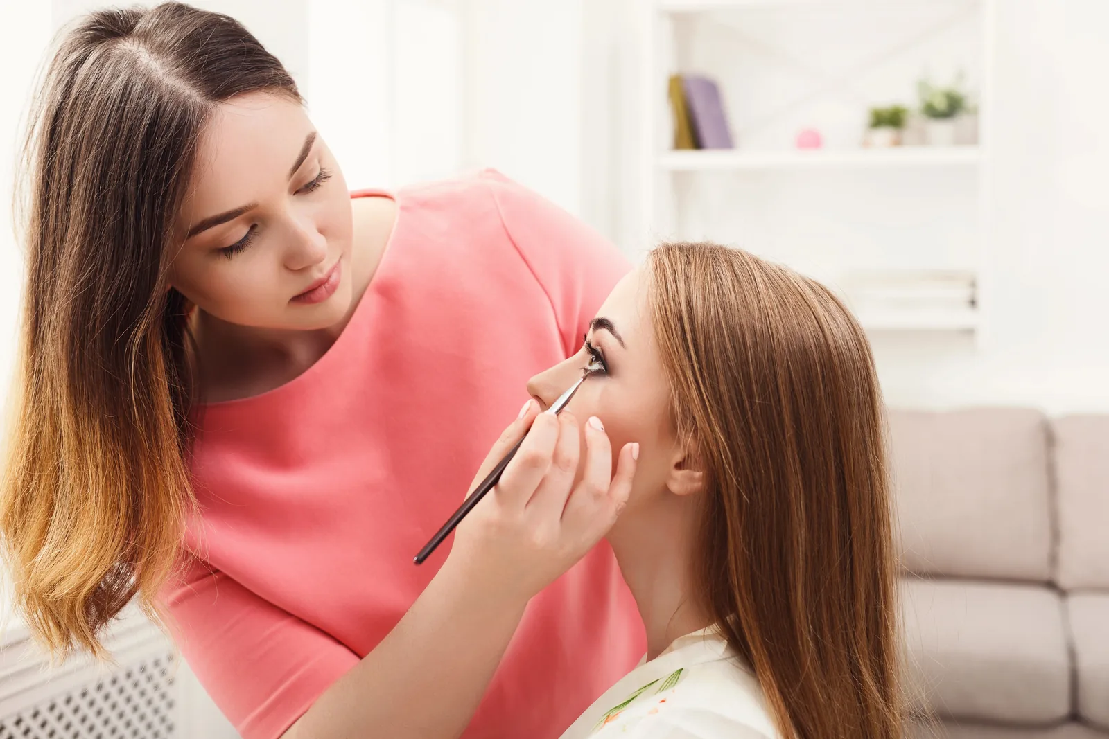 Make-up artist brengt oogmake-up aan.