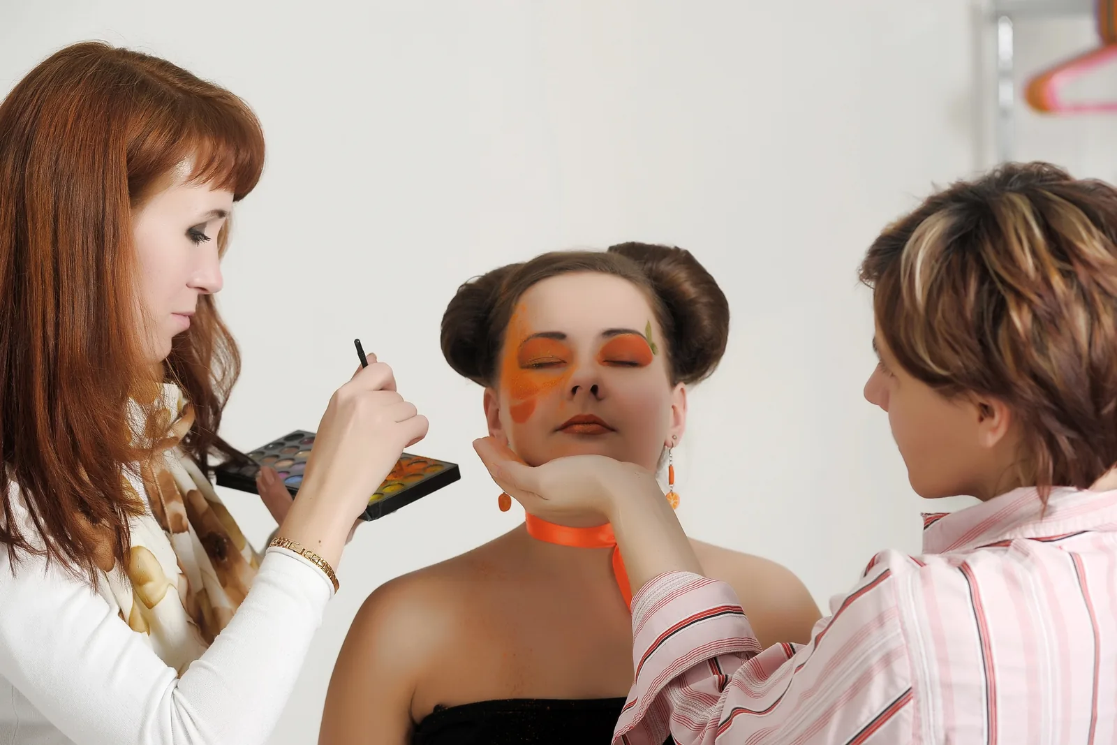 Make-up artists maken modellen klaar.