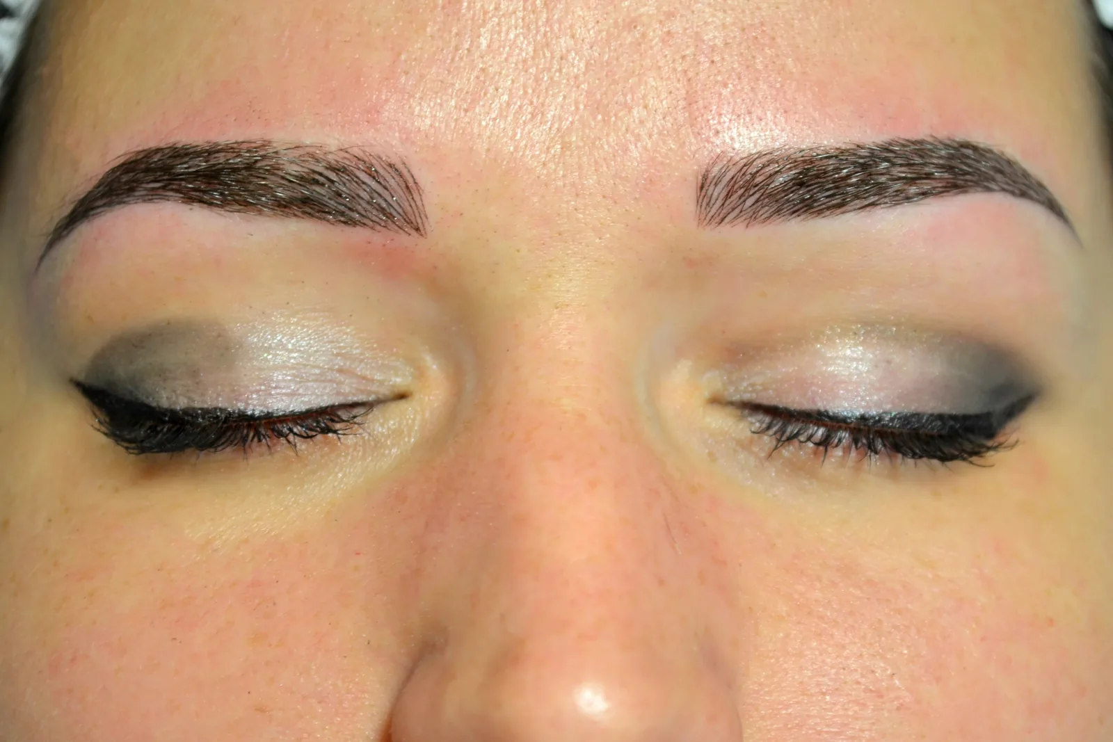Close-up van wenkbrauwen net na microblading, met fijne haarstrepen.