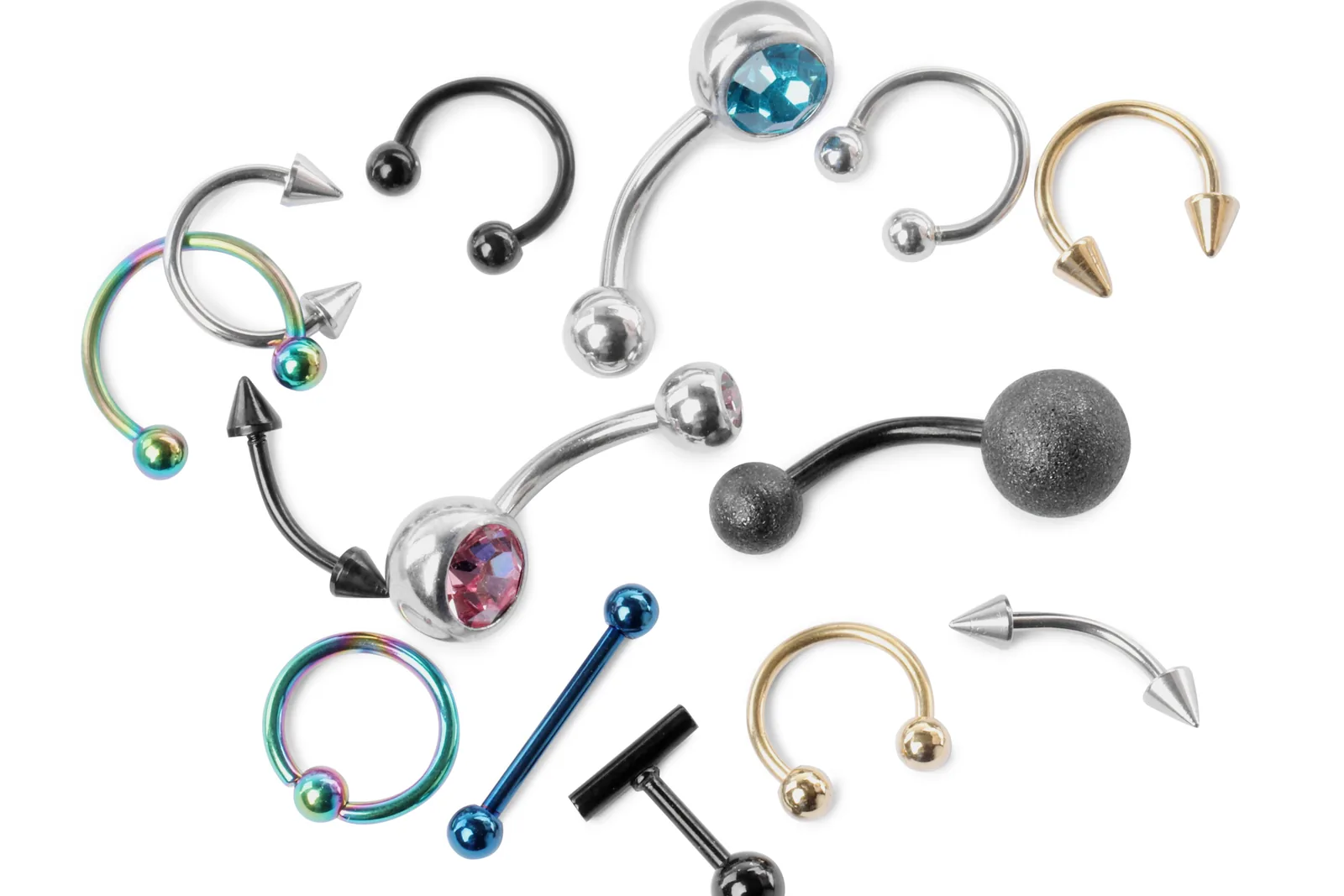 Verschillende piercingsieraden op een witte ondergrond.