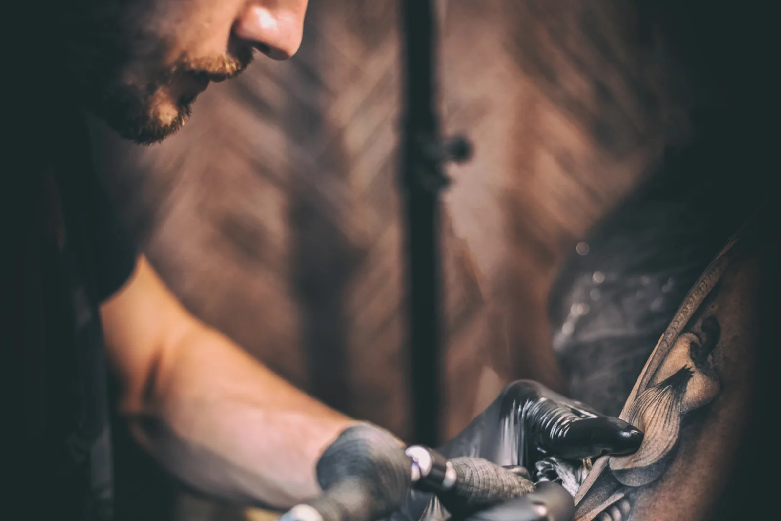 Tatoeëerder aan het werk in een donkere studio.