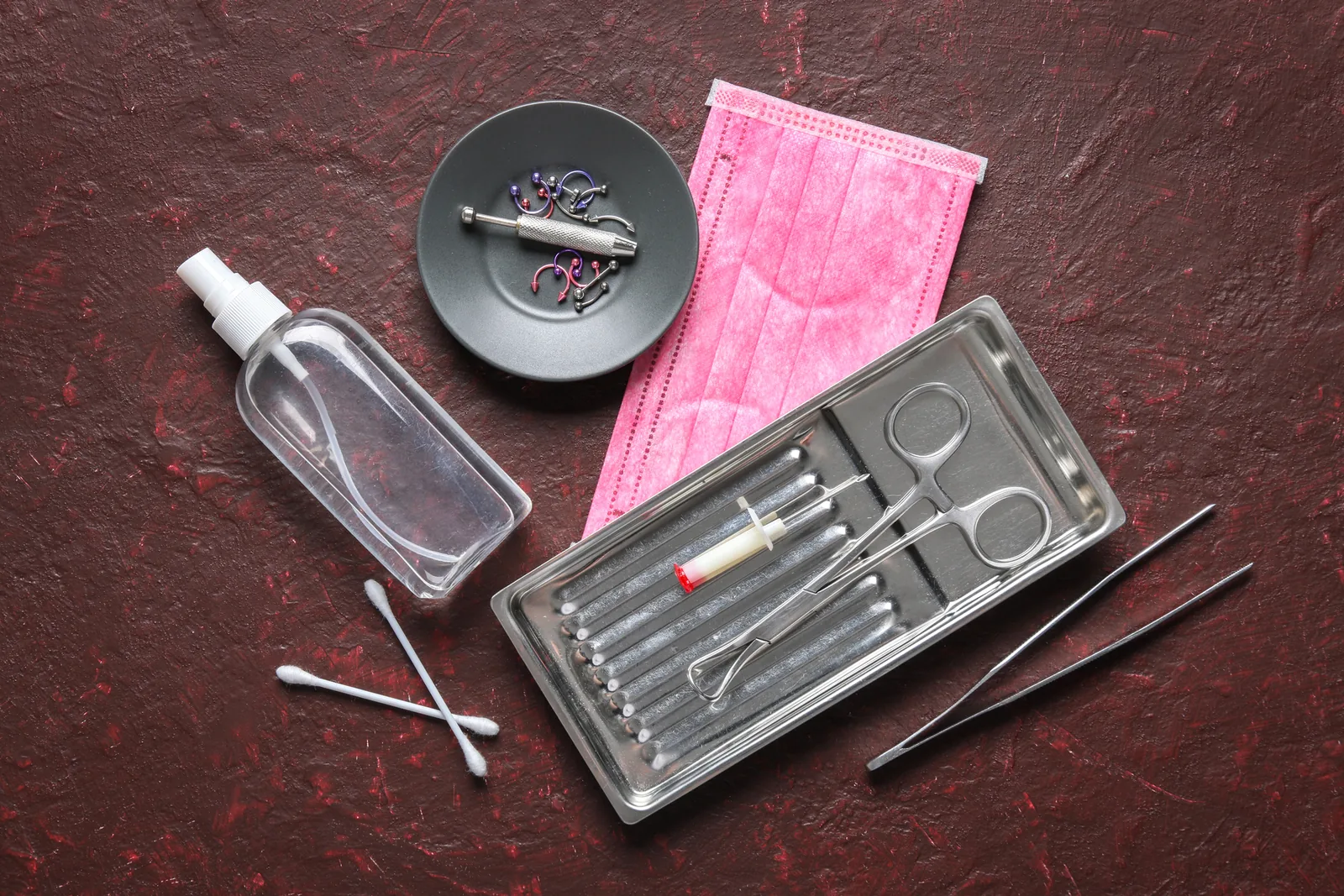 Steriel piercingmateriaal, sieraden en ontsmettingsmiddel op een tafel.