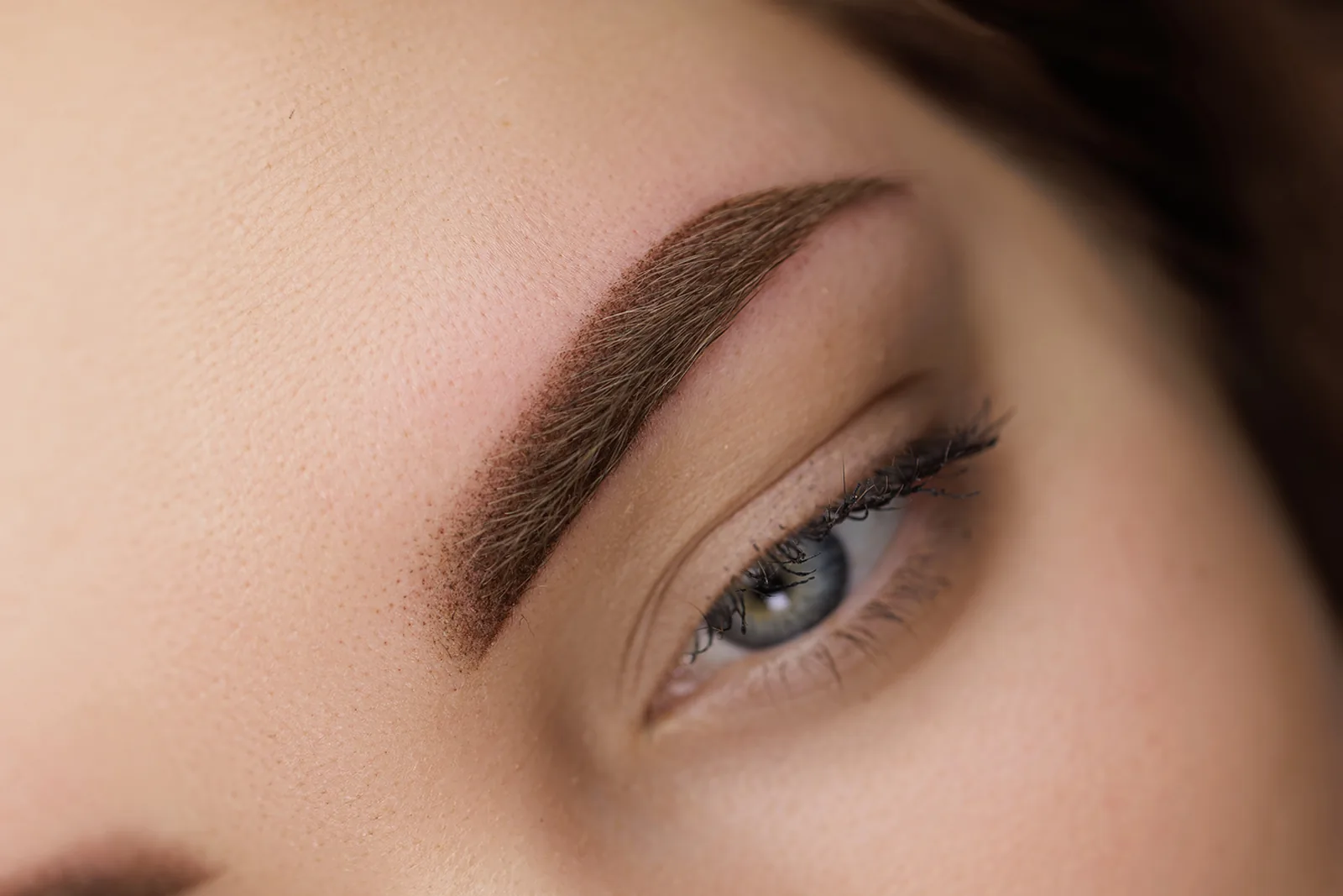 Close-up van een zacht gevulde wenkbrauw met permanente make-up.