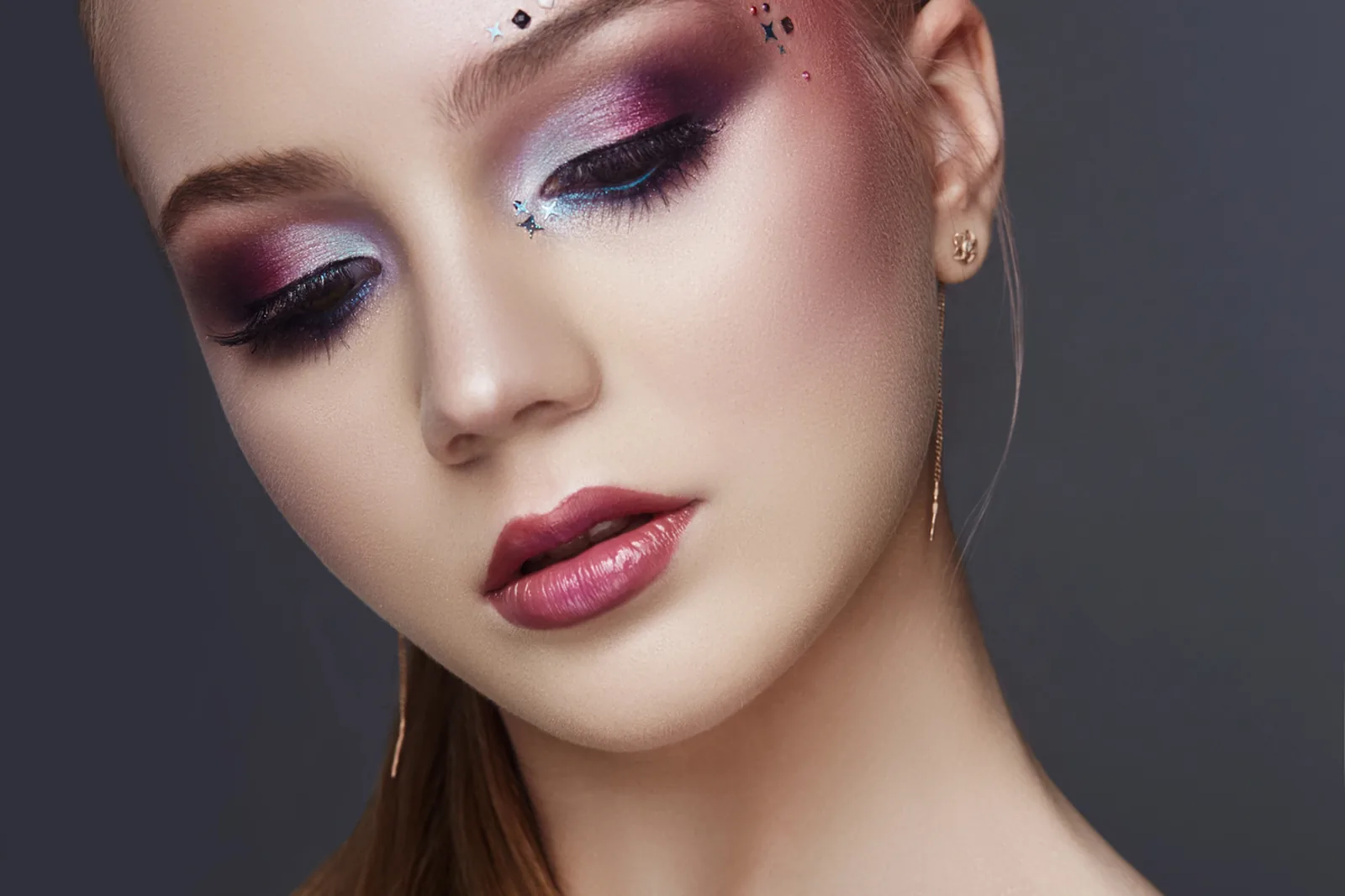 Vrouw met sterk gevormde wenkbrauwen en kleurrijke oogmake-up.