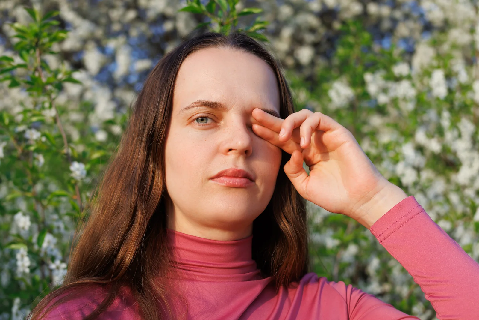 Vrouw raakt haar geïrriteerde oog aan.