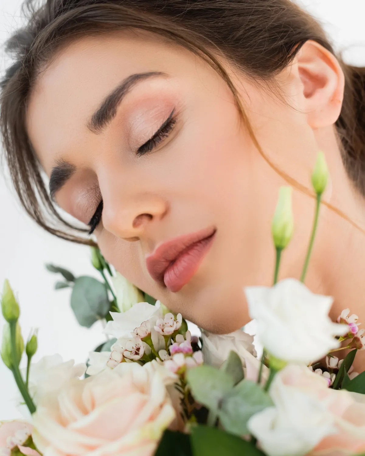 Bruid met een natuurlijke make-uplook en een boeket witte bloemen