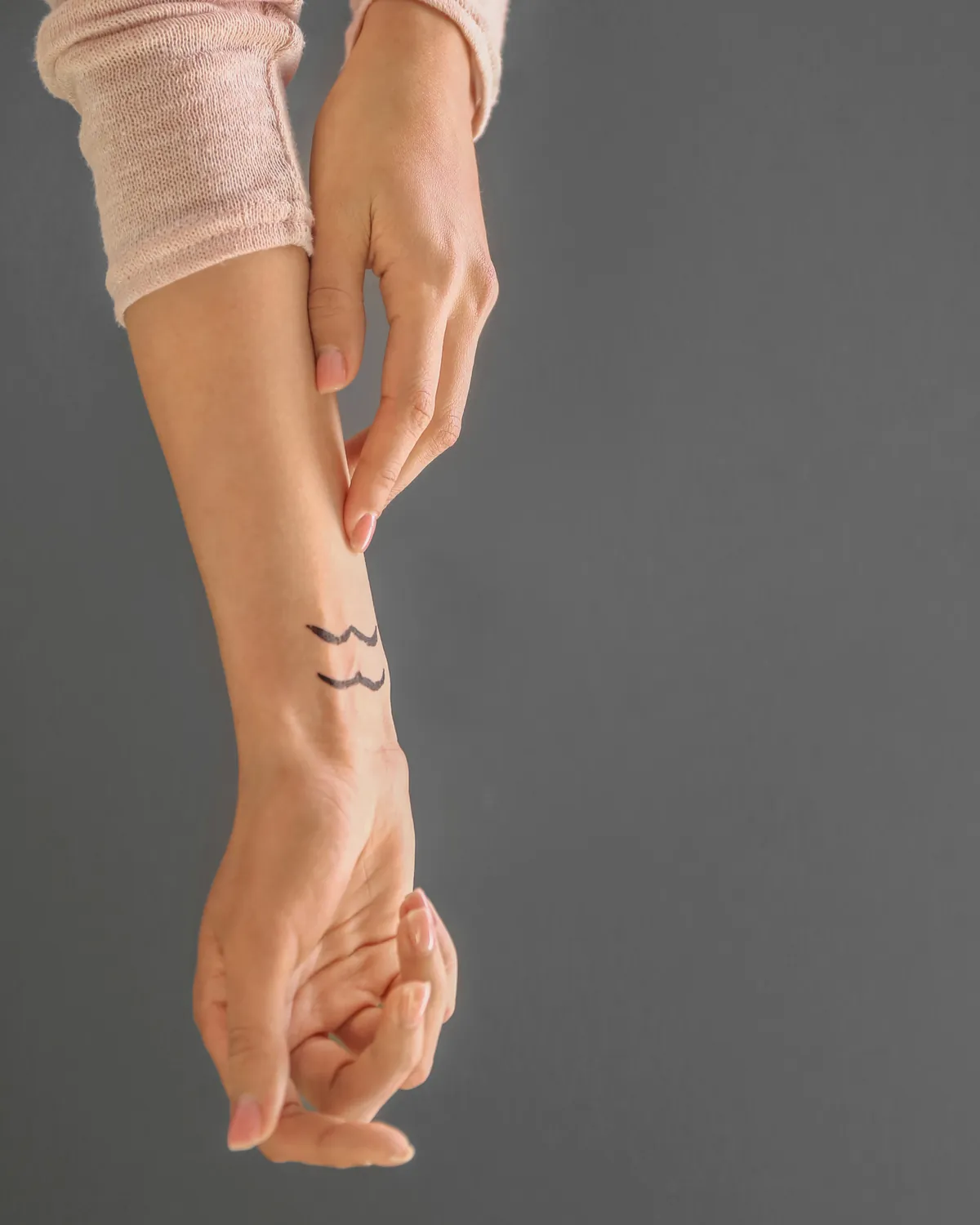 Klein symbool getekend op de binnenkant van de pols, als voorbeeld van een discrete polstattoo